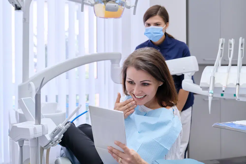Woman looking at her smile after her dental appointment