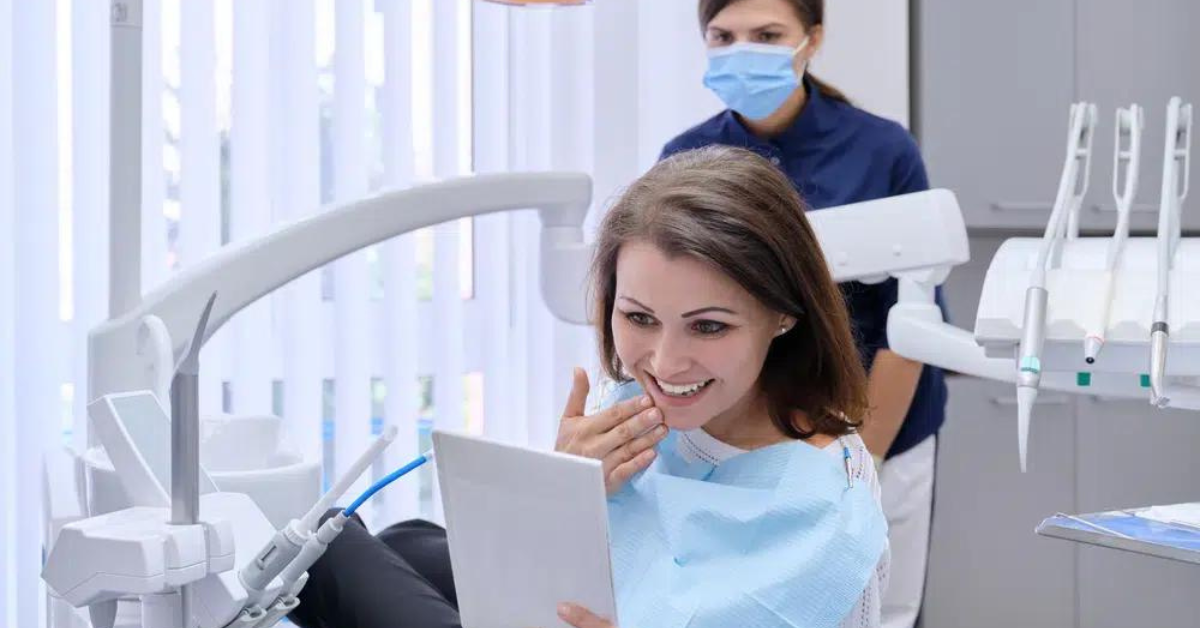 Woman looking at smile after dental appointment.