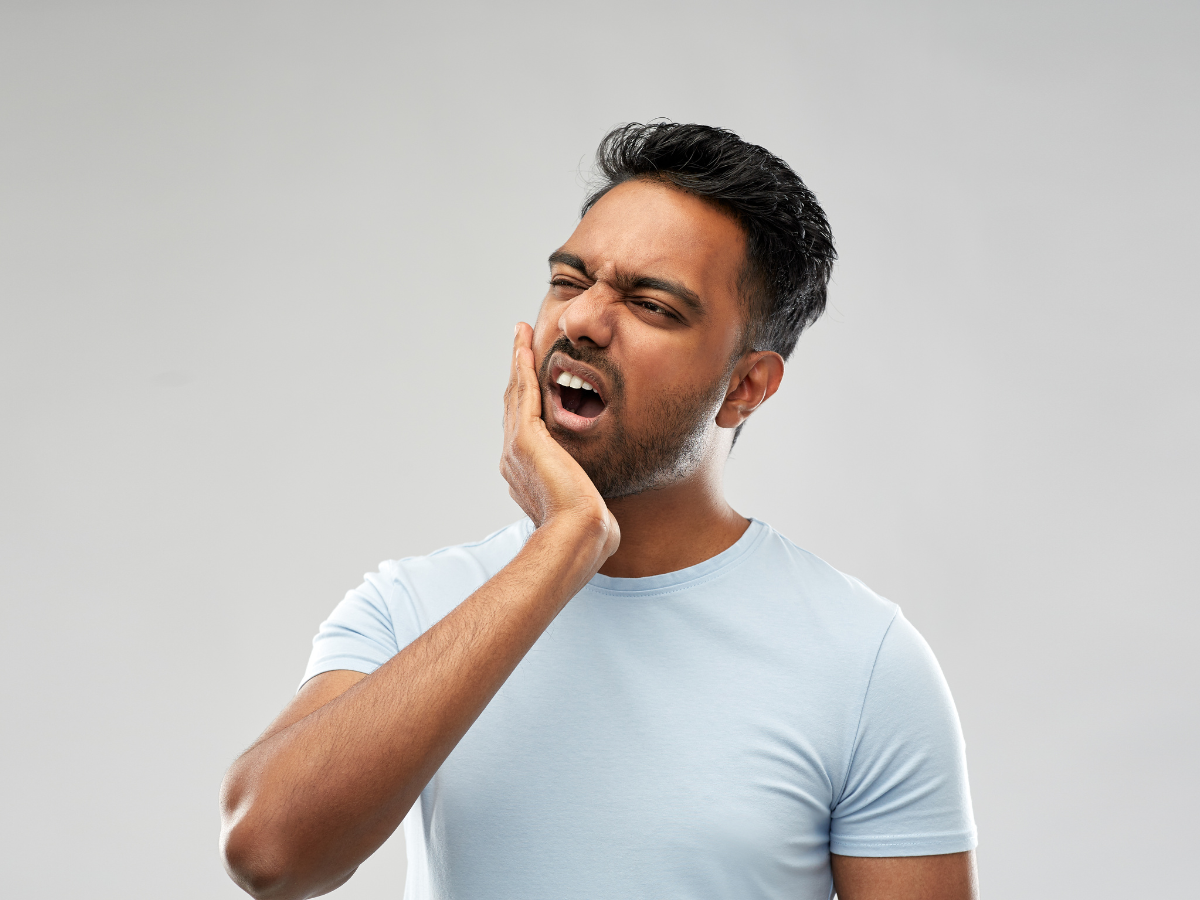 Man with hand on jaw having dental pain.
